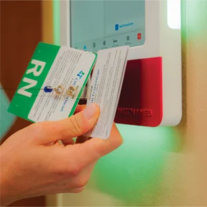 A nurse swipes her badge to enter a patient room using HallMonitor