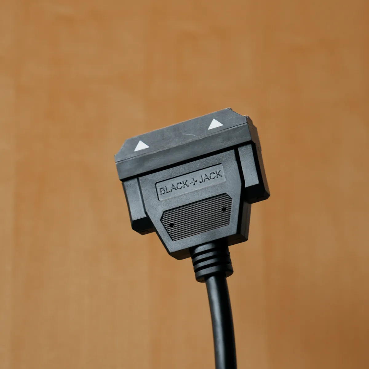 The magnetic end of a BlackJack cable, with the BlackJack logo and alignment arrows on its housing.