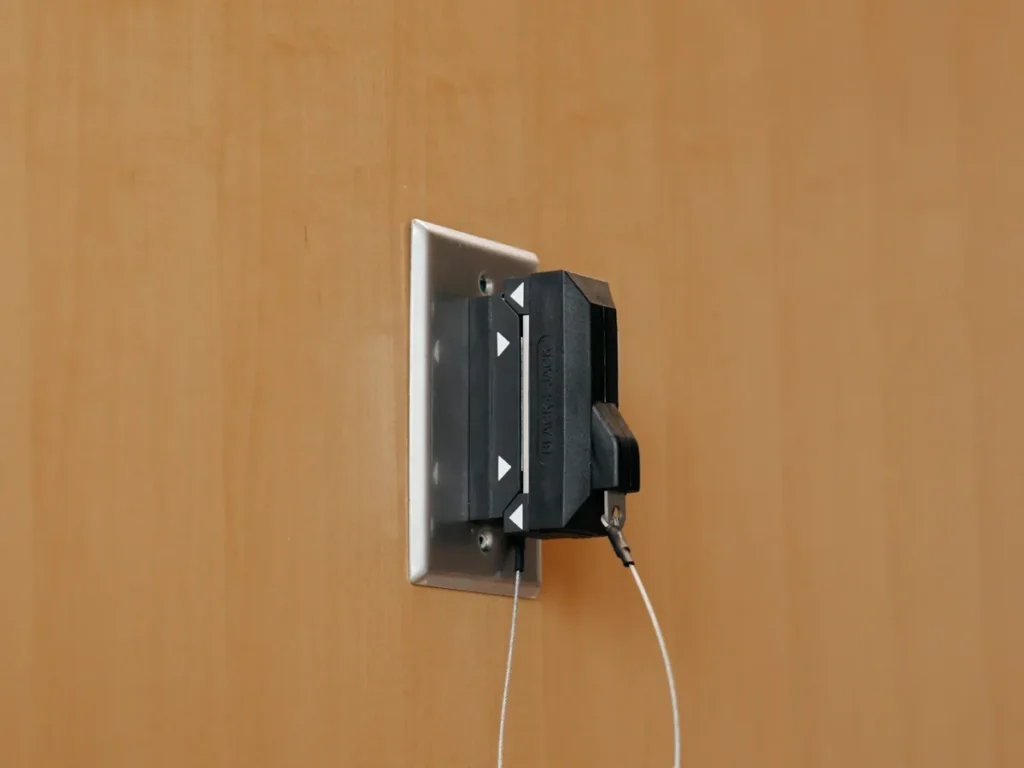 A cord-out dummy plug seated on a BlackJack magnetic wall brick, held by a thin lanyard.