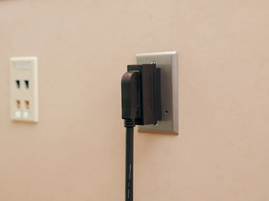 A right-angle BlackJack cable on a wall plate, its cable hanging straight down.