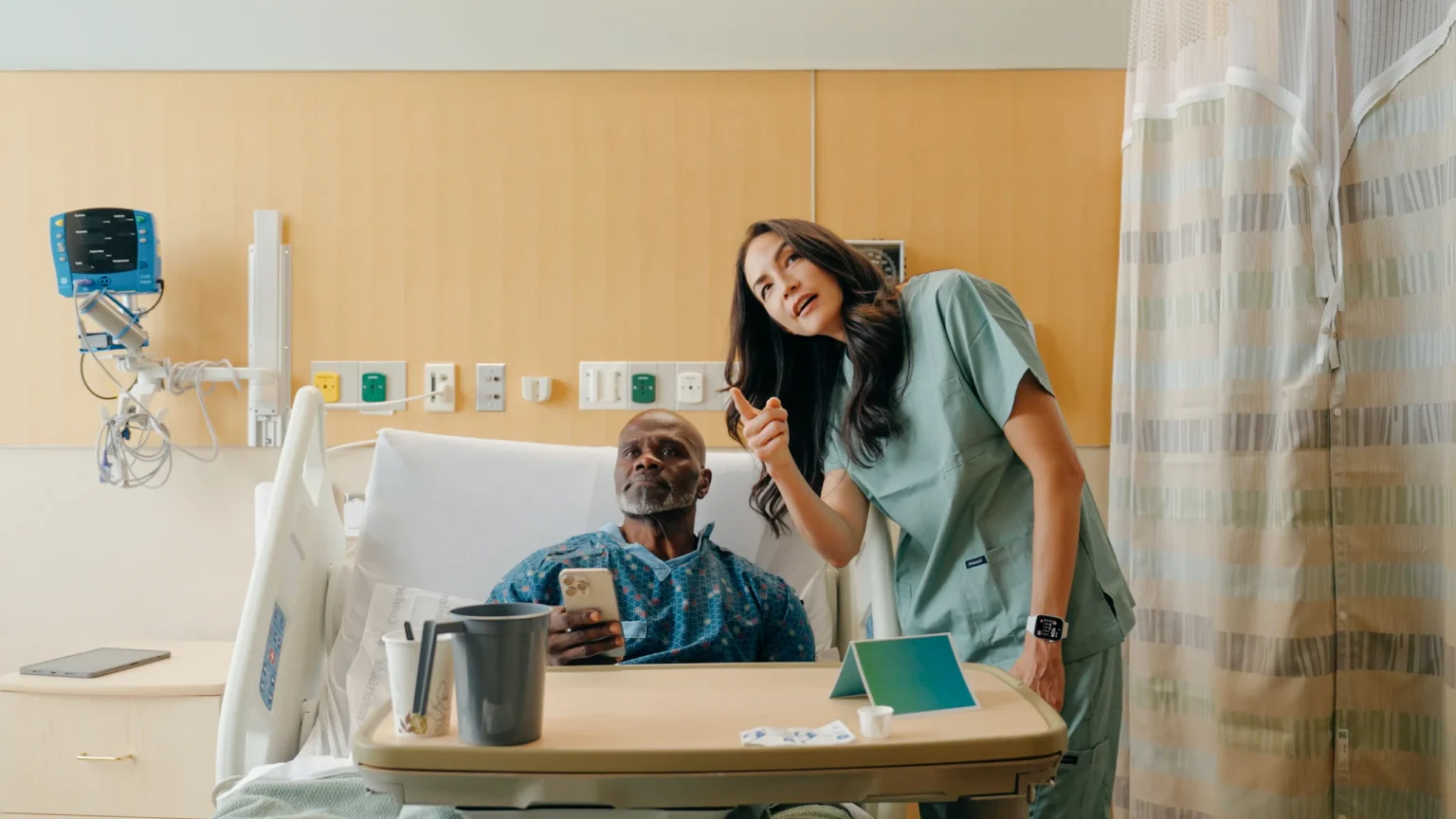 Patient and nurse together, patient holding a phone with ComCierge BYOD
