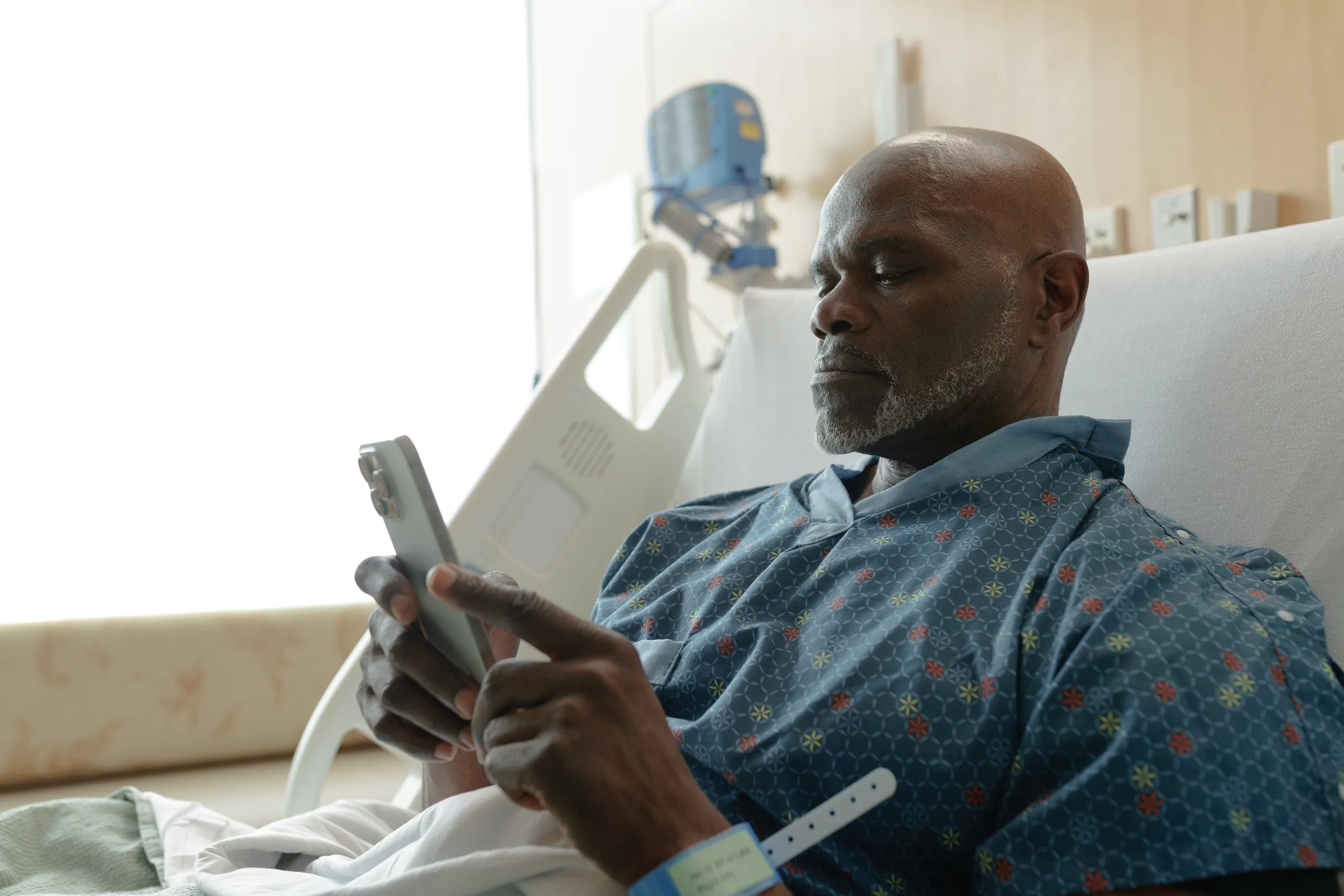 Patient in a hospital bed using ComCierge BYOD on a phone