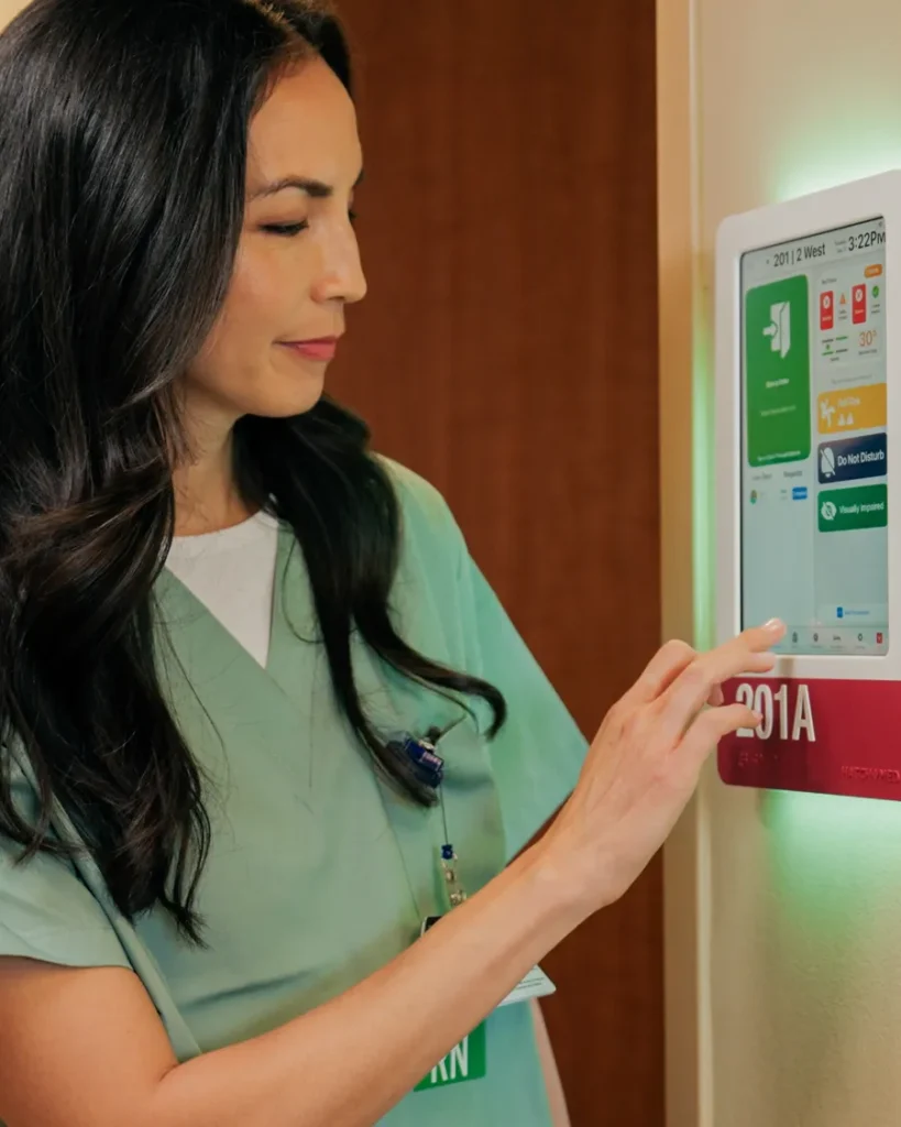A nurse checks a HallMonitor screen at the door of room 201A.