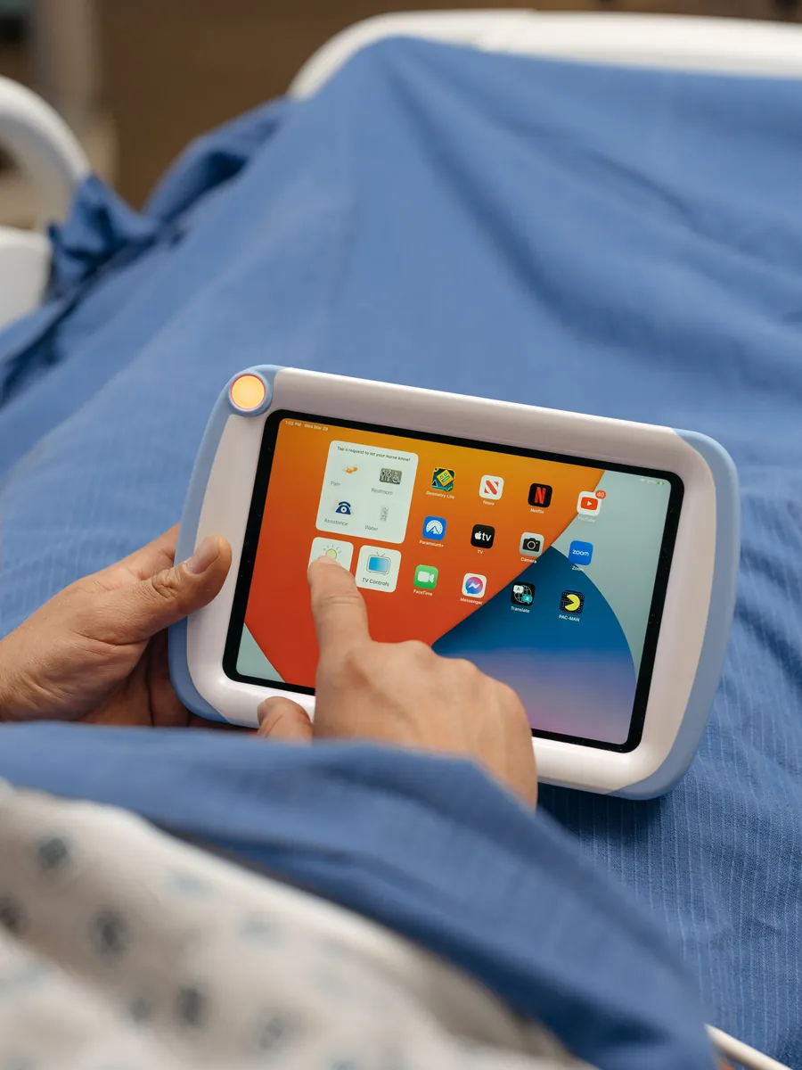 A patient taps an app on the iPad home screen inside a PillowCase.