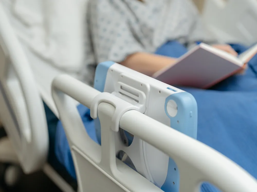 A PillowCase clipped to a bed rail while the patient reads a book.